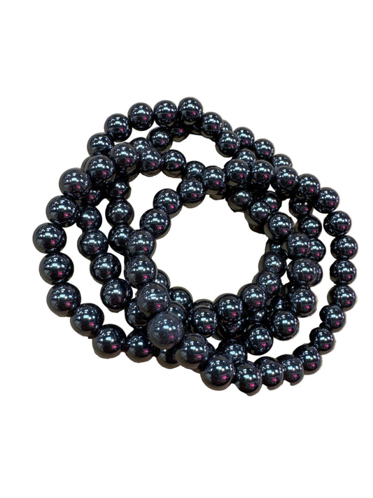 A stretchable bracelet made of round hematite beads, displayed on a white background